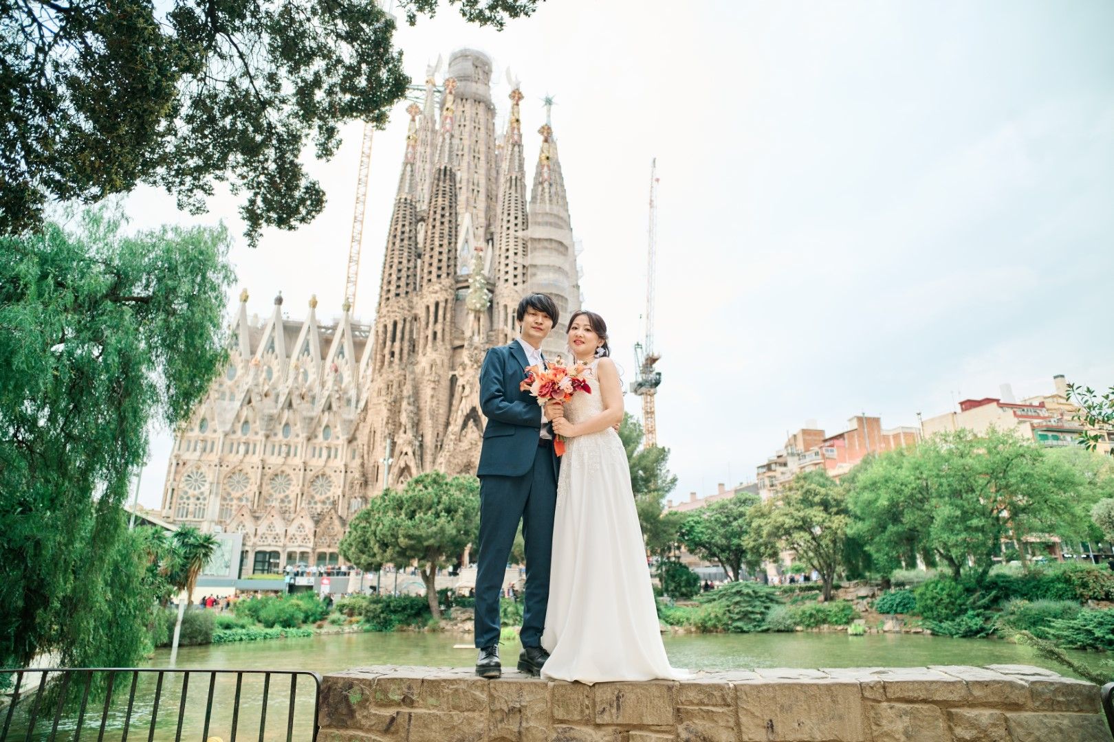 Japanese couple posing in front of Sagrada Família during honeymoon photoshoot in Barcelona