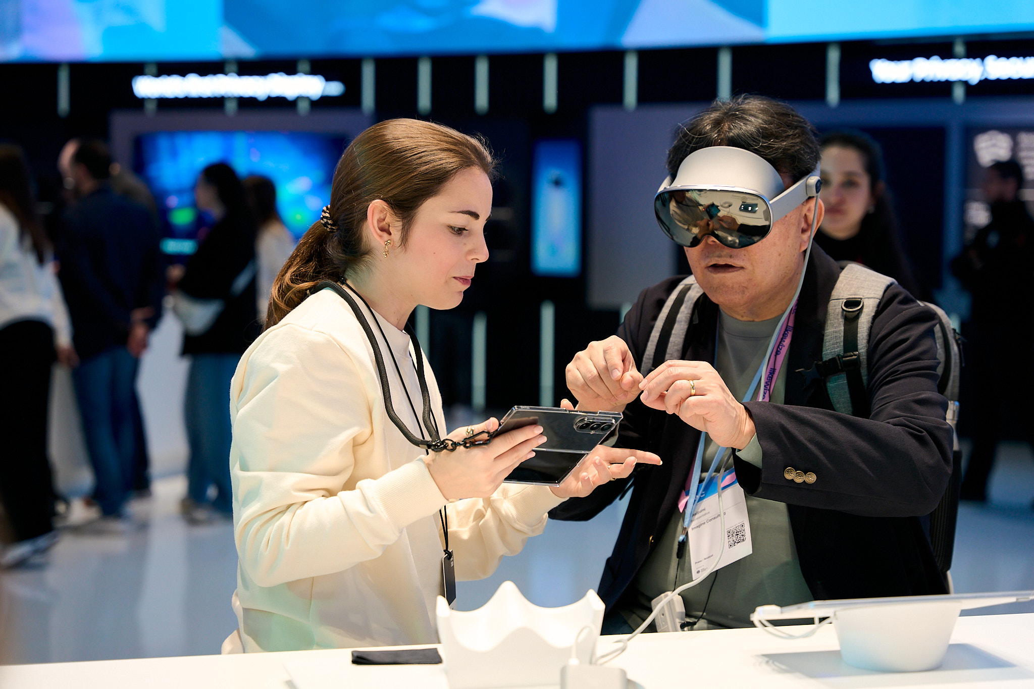 Attendees engaging with virtual reality and foldable phone technology at mwc